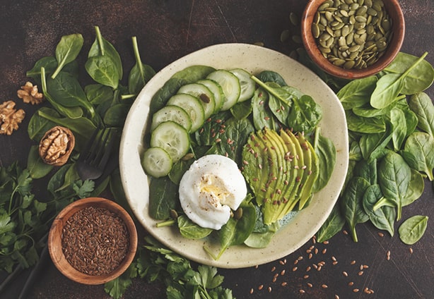 Green salad with spinach, avocado, egg, flax and pumpkin seed. Food background. Detox Vegetarian Healthy Food Concept. Top view, copy space.